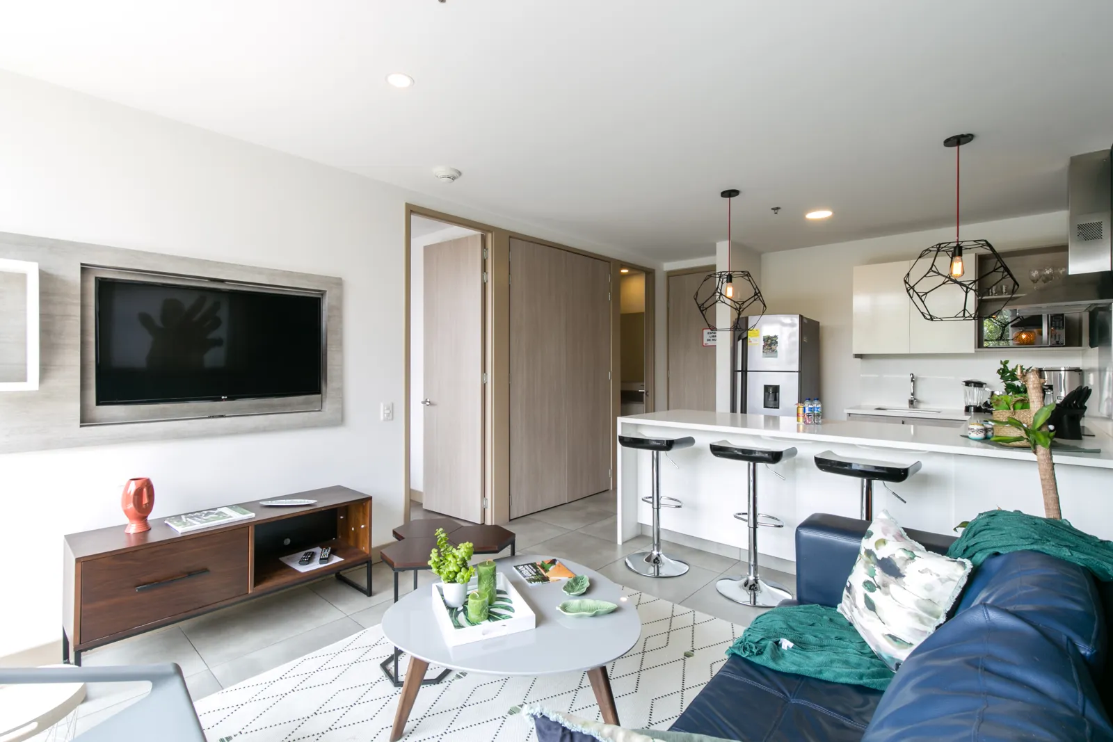 Living room with TV and open-plan kitchen in the apartment for sale at Soul Lifestyle