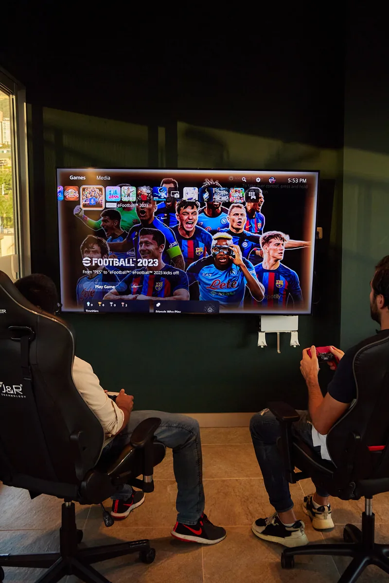 Guest playing video games in the game room at Soul Lifestyle Apartments