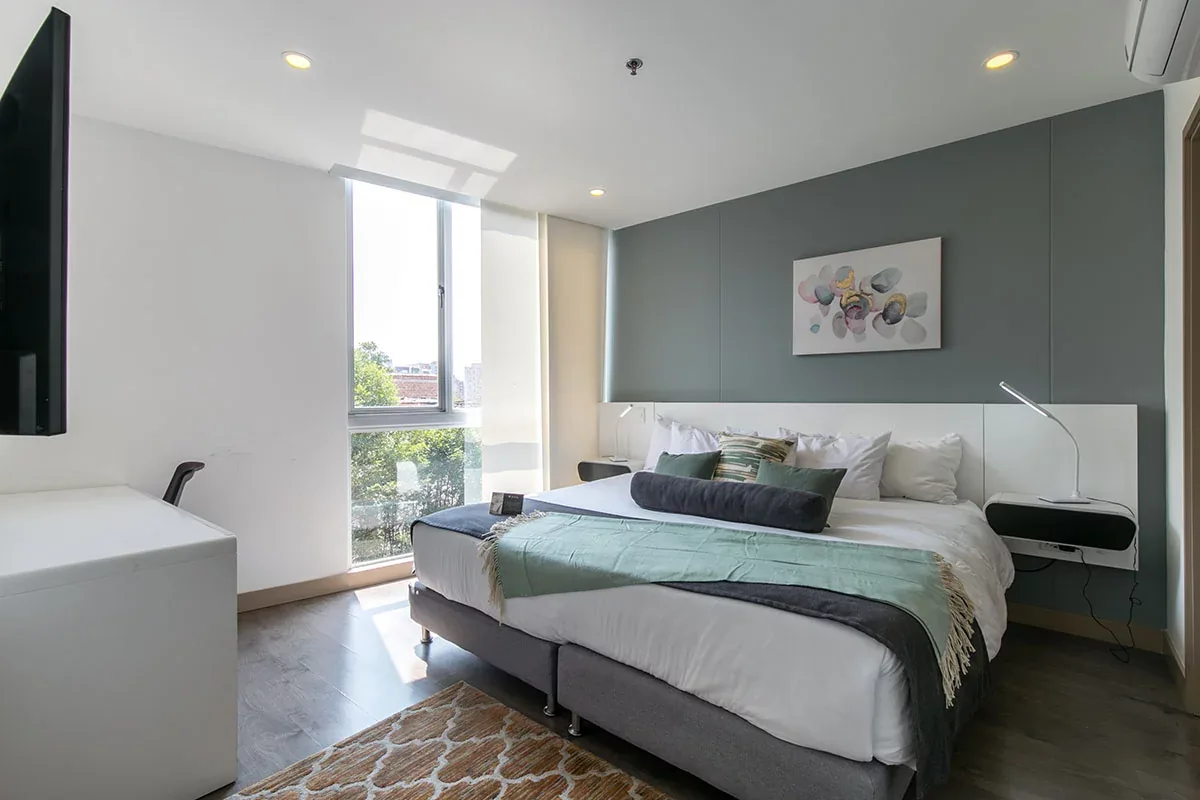 Bedroom with green accents in a Classic apartment at Soul Lifestyle Apartments