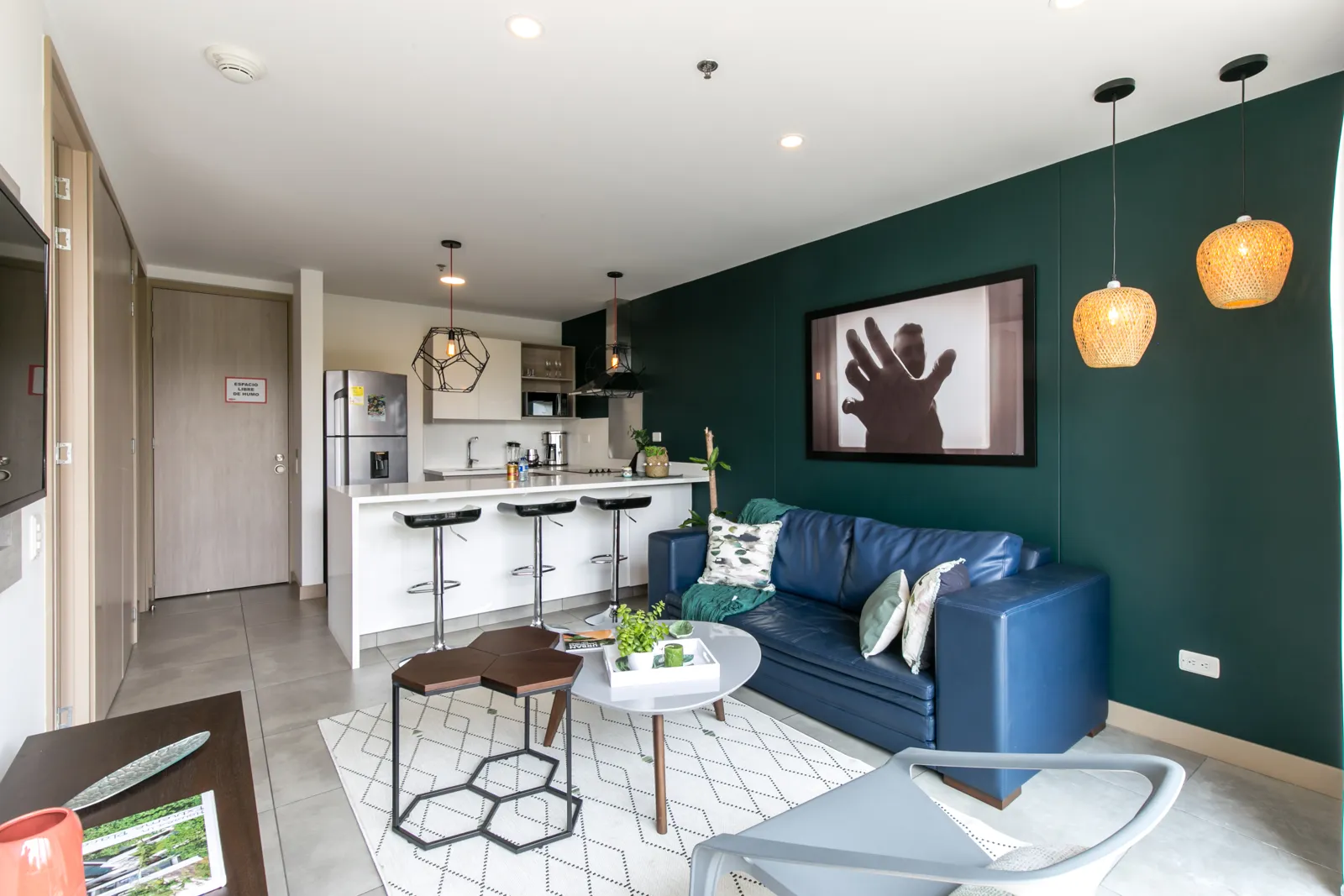 Living area with blue sofa and open kitchen in the apartment for sale at Soul Lifestyle